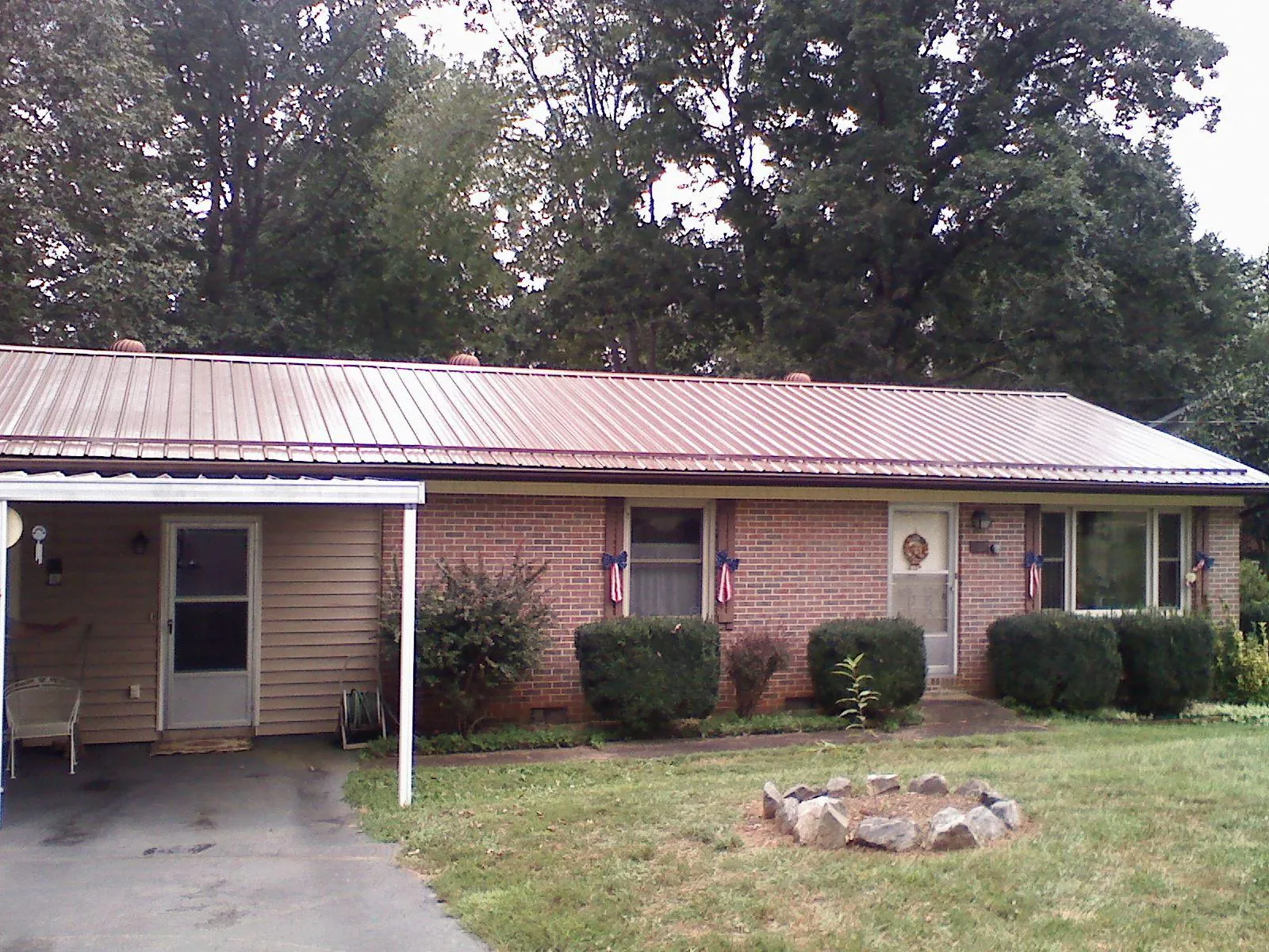 Bronze metal roof and carport on a brick ranch home — Roof Repair work by our crew in Hudgins
