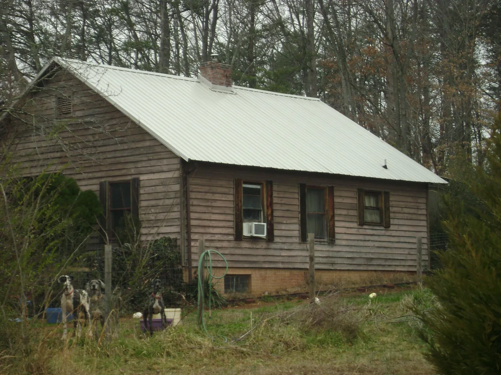 White metal roof on an old wood sided farmhouse, from a Metal Roof Installation job in Hudgins